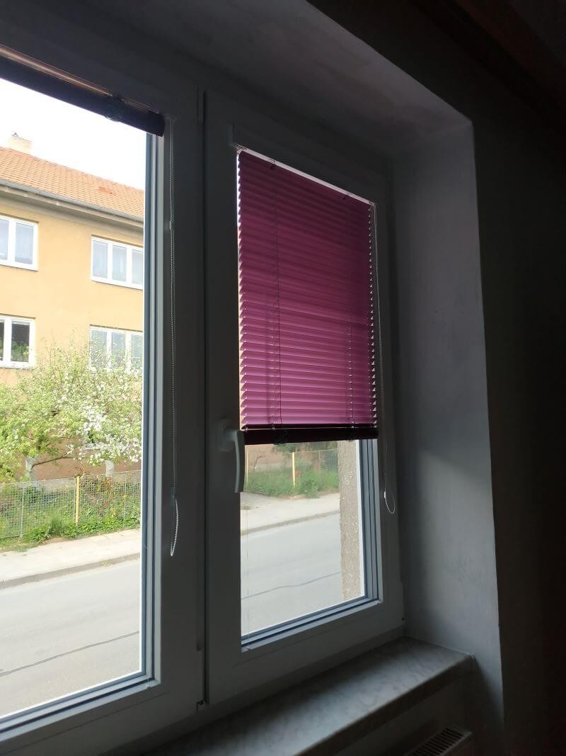 Fialové vnitřní žaluzie na bílém okně