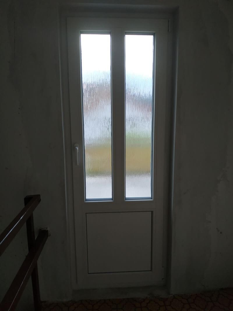 Parapetové bílé dveře vedoucí na terasu